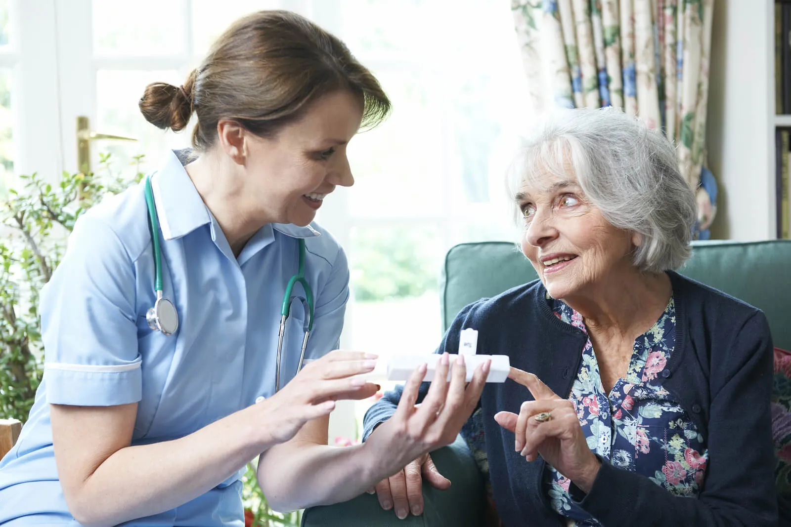 Nurse taking care of an elderly patient in her home